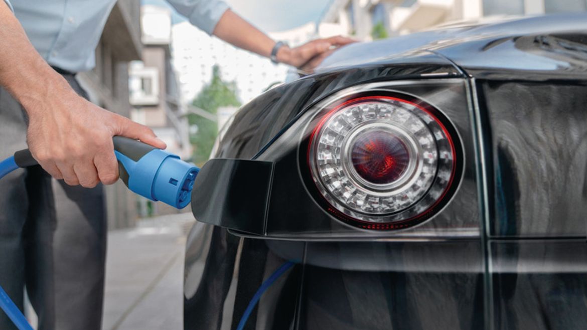 Hombre cargando su vehículo eléctrico