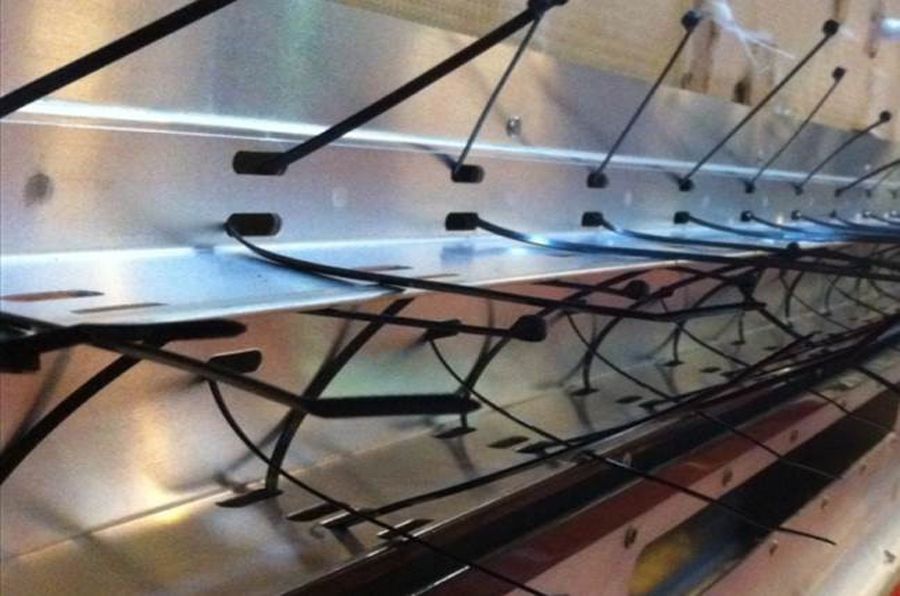 Bridas para cables dobladas a través de los orificios de la bandeja